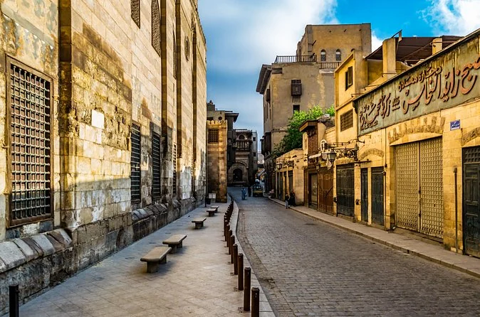 Un tranquillo vicolo di pietra nel Cairo islamico con vecchie facciate e persiane chiuse nella luce del mattino