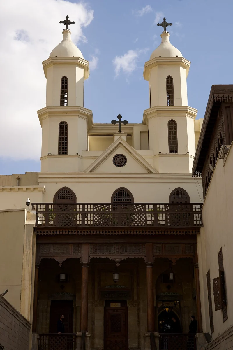The two bell towers of the Hanging Church topped with crosses against a pale sky