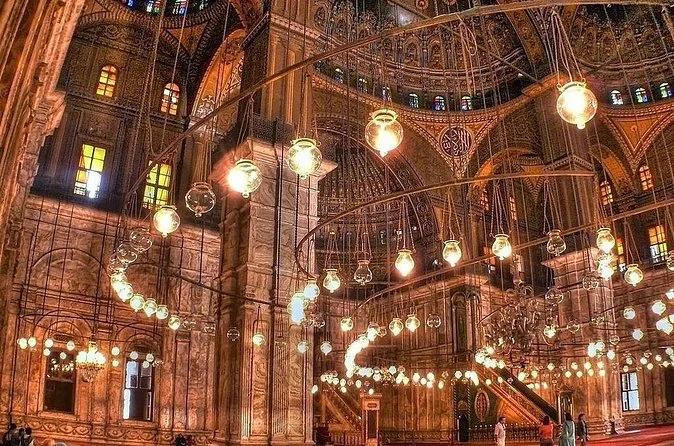 Rings of glass lamps hanging under the painted domes inside the Muhammad Ali Mosque